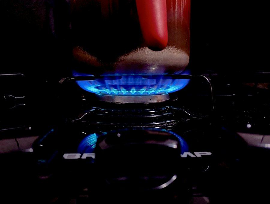 Quemador de gas encendido con una mano cerca, revisión de red de gas en Concón